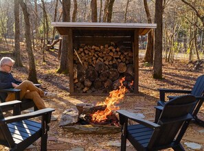 Firepit with complementary firewood and modern Adirondack chairs.