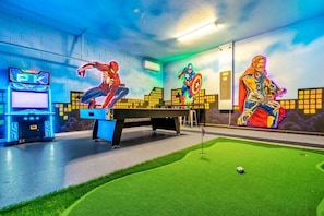 Garage-turned-games-room with putting green and billiards table.