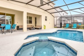 Screened-in back sundeck with swimming pool and jacuzzi hot tub.