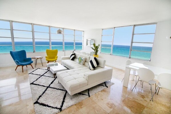 Living room with dining areas, and balcony.