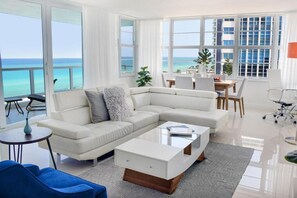 Living room with dining areas, and balcony.
