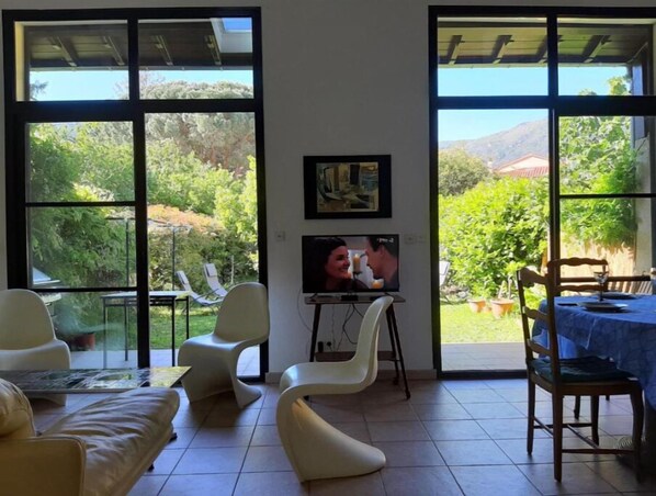 Le salon avec ses vastes baies ouvertes sur le jardin