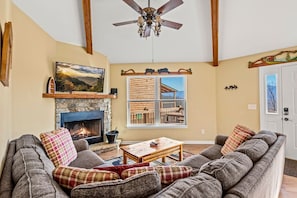 The living room includes a comfortable sectional, fireplace (seasonal) and large Smart TV.