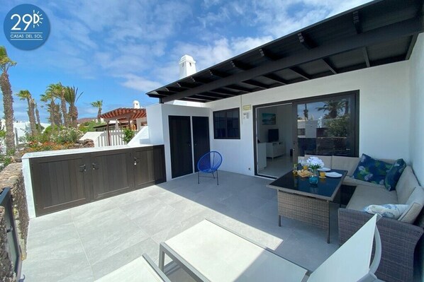 South facing patio corner seating with table, 2 loungers, enclosed pergola