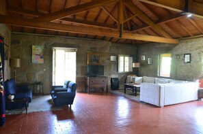 Spacious living room with high ceilings, seating area and a TV. #comfort #airbnb