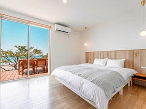 ・[Bedroom] Spacious queen bed for a comfortable night's sleep. A bedroom overlooking the sea