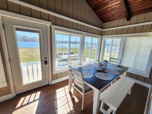 Sunroom overlooking the lake with dining table and seating.