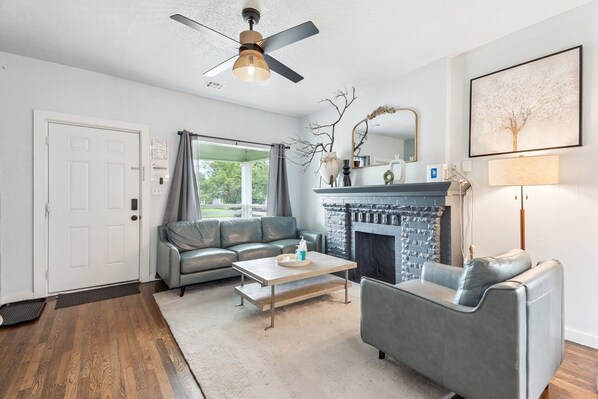 Step into a light-filled living room with large windows, sleek leather seating, and a cozy fireplace—perfect for lounging after a day of exploring OKC.