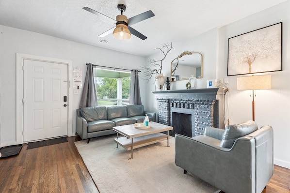 Step into a light-filled living room with large windows, sleek leather seating, and a cozy fireplace—perfect for lounging after a day of exploring OKC.