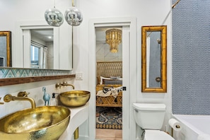 Luxe spa-inspired bathroom with gold vessel sinks, high-end fixtures, and bold styling—because your stay should feel indulgent.