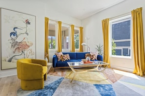 Open floor plan connects kitchen to a colorful, art-inspired living room—ideal for relaxing or entertaining in Midtown Atlanta.