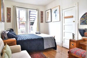 Spacious east bedroom with comfy queen bed, loveseat, art deco vanity and lots of closet space.