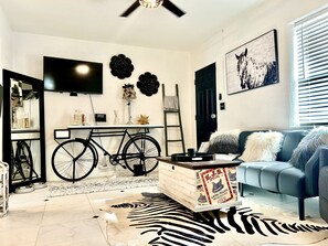 Living room area with futon  couch with recliner and cozy fireplace.