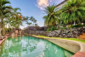 Dive into a private saltwater pool, embraced by lush tropical surroundings.