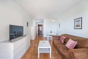 Bright and cosy living room, with a comfortable sofa to relax, and a Smart TV.