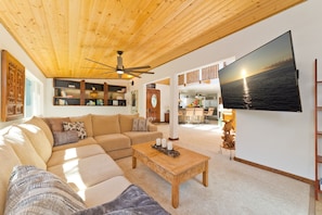 Living room looking towards entryway and kitchen - Living room with large flat screen TV