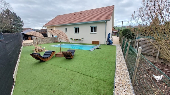 Piscine avec espace détente, table pour enfant avec bac à jeux.