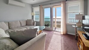 Living room with comfortable sectional, TV and water views