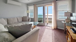 Living room with comfortable sectional, TV and water views