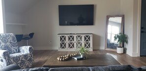 Living room with sleeper sofa, television, and recliners.