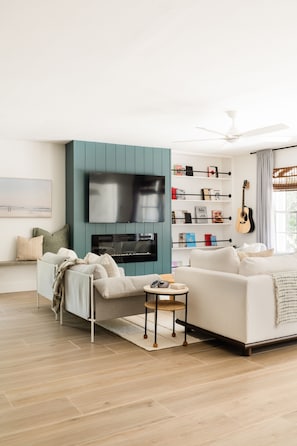 Living Room Area with Fireplace and Large Smart TV and Sofa Bed
