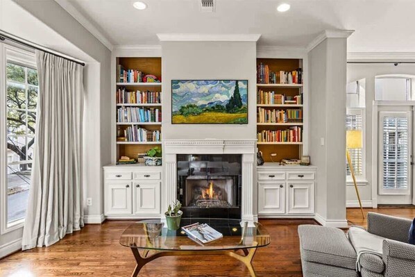 Living room with frame TV and fireplace. 