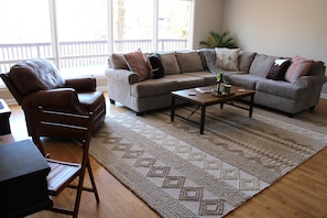 Living room on main level with sectional sofa, desk for dedicated workspace