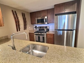 Our minimalist kitchen, featuring a sleek countertop and convenient sink for your culinary needs.