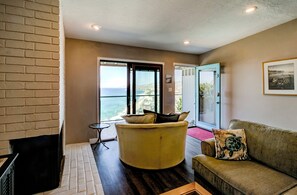 Living room has whitewater ocean views and a fireplace.
