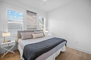A well-lit bedroom with a cozy bed, stylish decor, and large windows for natural light.