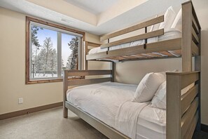 Second bedroom with a single-over-double bunk bed, a Smart TV, walk-through closet and ensuite access to the second bathroom.