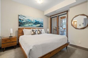 Primary bedroom with a King bed, access to the balcony, walk-through closet and a private ensuite full bathroom.