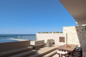 Premium day beds with bespoke dining settings overlooking the Aegean Sea. 