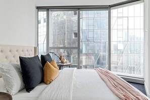 The master bedroom with a queen sized bed & plush pillows.