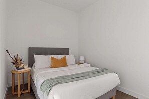The 2nd bedroom with a double sized bed & plush pillows.
