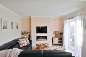 Spacious lounge with TV , patio doors and fireplace