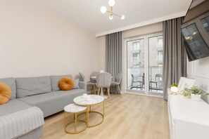 Cozy living room with a soft gray sofa, a chic round coffee table, and warm lighting.