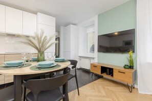 Living area with double sofa bed, Smart TV and kitchenette with dining area