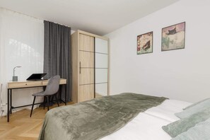 Cozy bedroom with comfortable double bed, closet with mirror and desk with chair