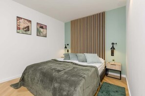 Cozy bedroom with comfortable double bed, closet with mirror and desk with chair