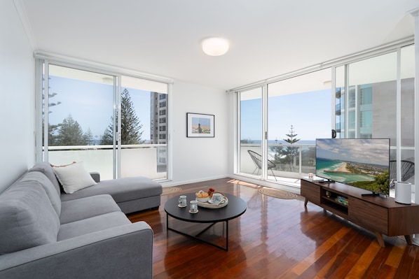 Living room with ocean view - Relax in this bright, breezy and open plan living room with smart TV and beach and ocean views.