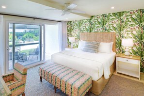 Main bedroom with king bed and large sliding doors opening onto tropical garden.