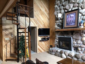 Stonehedge 2 - Living Room with Cable TV/DVD, Gas Fireplace, and Large Leather Sofa. Spiral Staircase from Sleeping Area where you enter the unit and goes down to Lower Level where Kitchen and Living Room Area is located.
