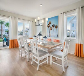Bright dining room accented with touches of coral, offering a refreshing space for family meals.