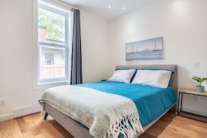 Bedroom 4 is minimalistic beauty w/a queen size bed, an armoire & a window for natural light.