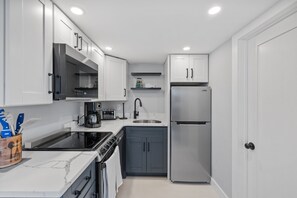 Kitchen with coffee maker, toaster, and all standard appliances, including dishwasher.