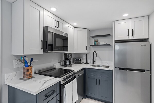 Kitchen with coffee maker, toaster, and all standard appliances, including dishwasher.