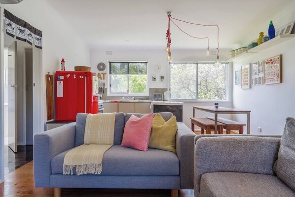 A sun-drenched open floor plan houses a kitchen, living and dining area.