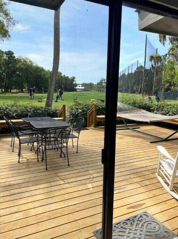 View looking out on the deck with the driving range behind it.