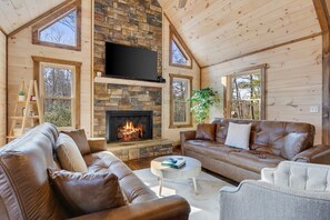 Lining the entire cabin is beautiful pine tongue and groove, and at the center of the home, the great room featuring floor-to-ceiling natural light, fireplace, Smart TV, and plenty of comfortable seating.